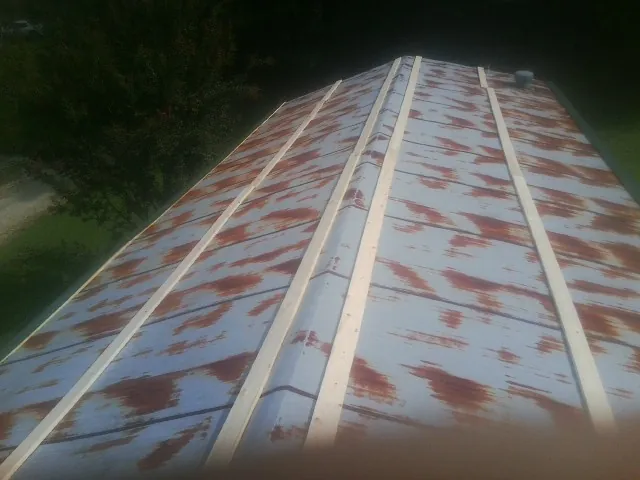 Rusted metal roof panels with new wood purlins before replacement — Storm Damage Roof Repair in Casco by Roofing Brothers