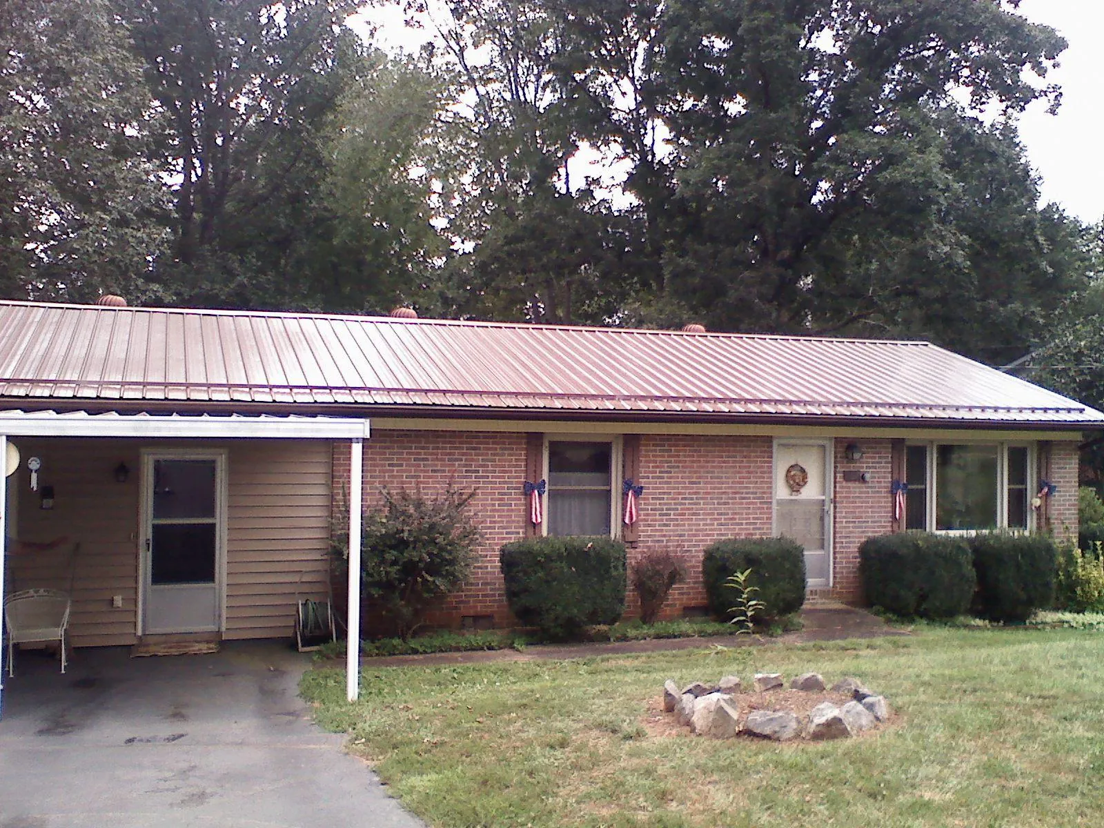 Bronze metal roof and carport on a brick ranch home — Roof Repair work by our crew in Casco